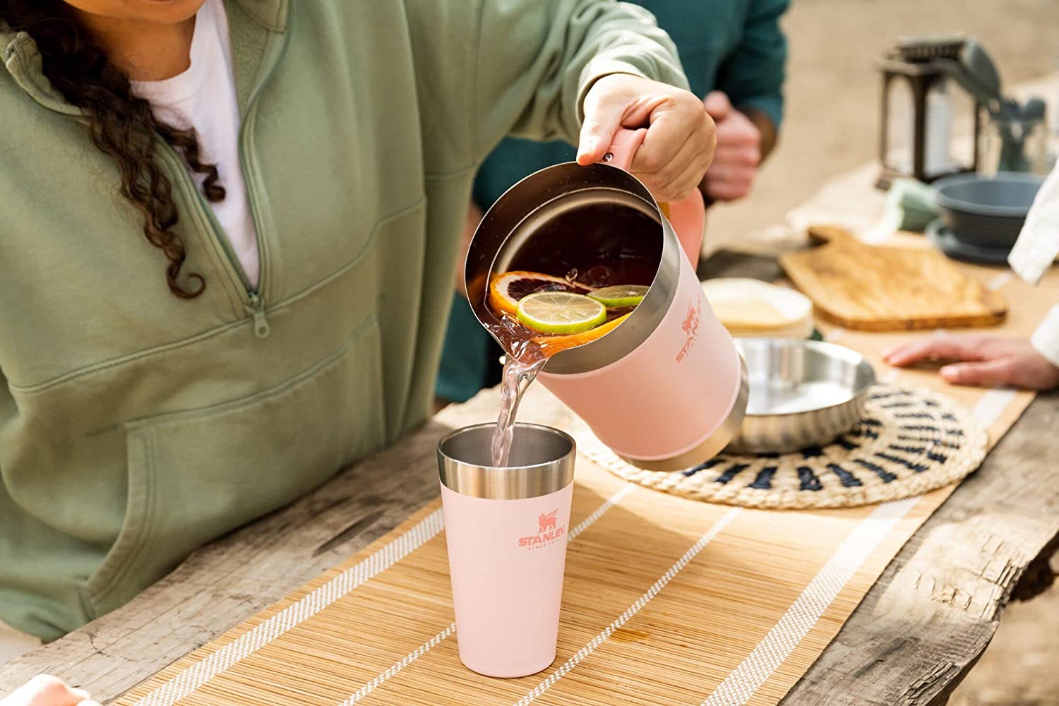 Woman pouring beer into a pink Stanley beer pint.