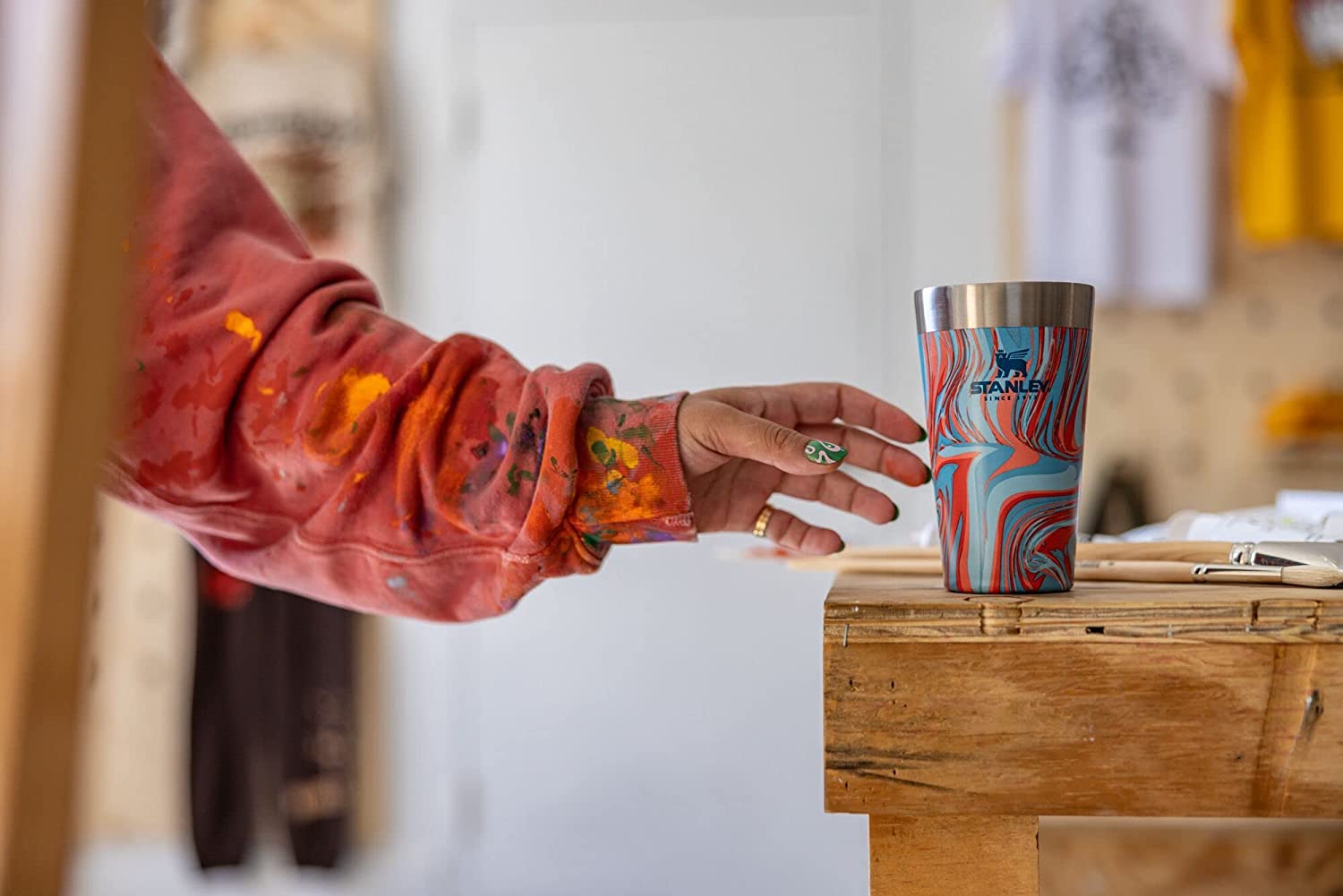 Women grabbing a Stanley bee pint in Pool Swirl colors.