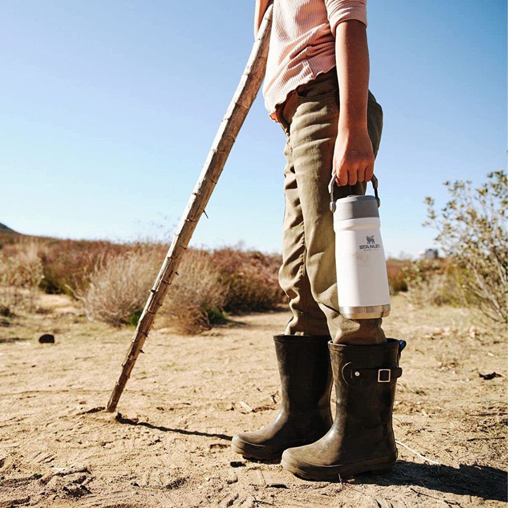 Young girl hiking carrying a white Stanley Iceflow tumbler.