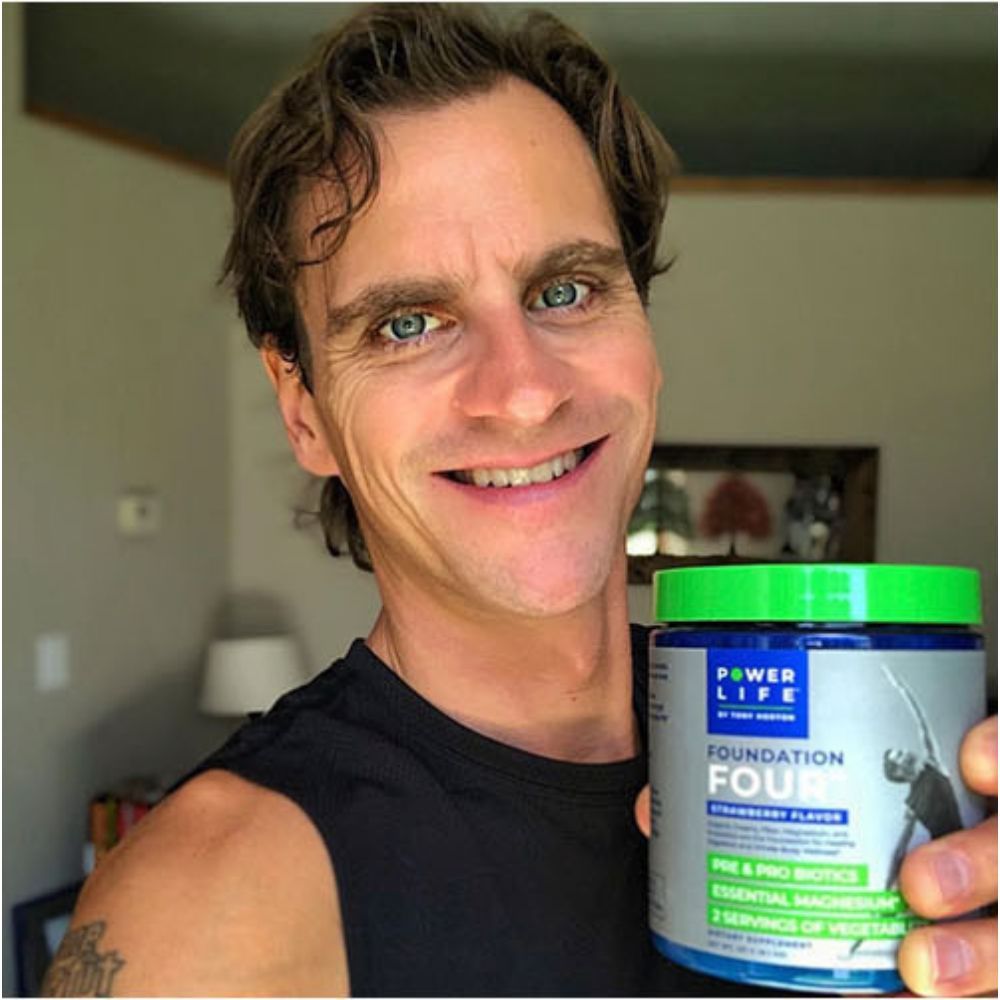 Man smiling while holding a jar of Power Life Foundation Four
